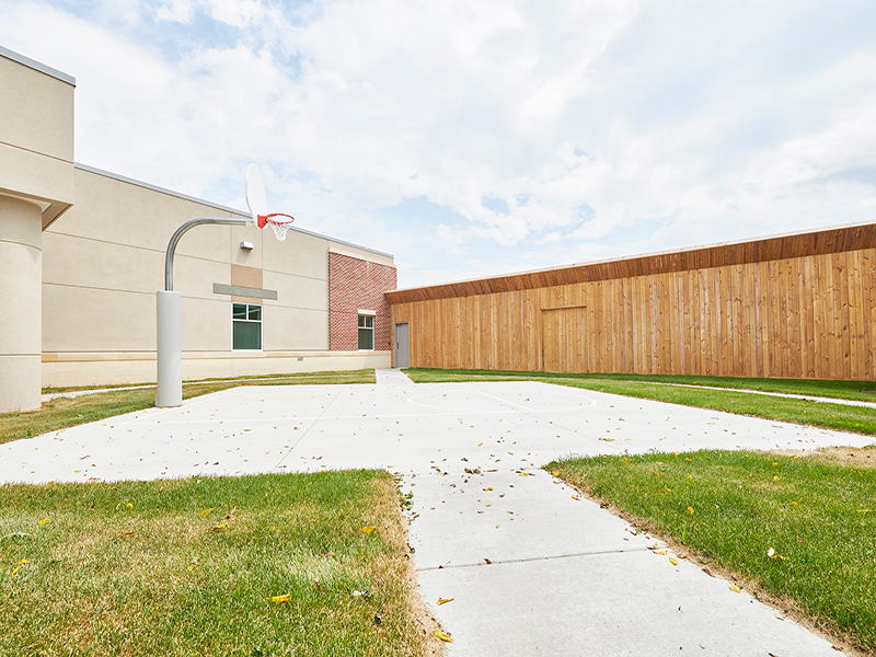A basketball hoop in a grassy courtyard at Tower Behavioral Health