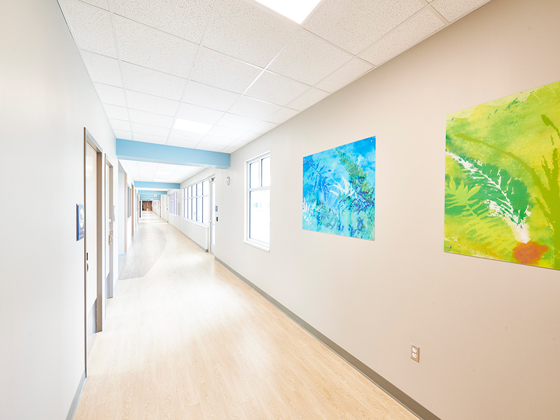 A hallway decorated with bright paintings at Tower Behavioral Health